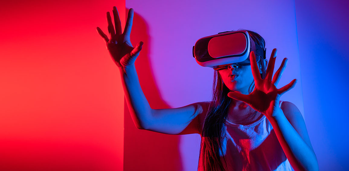 Young woman using glasses of virtual reality on dark background.