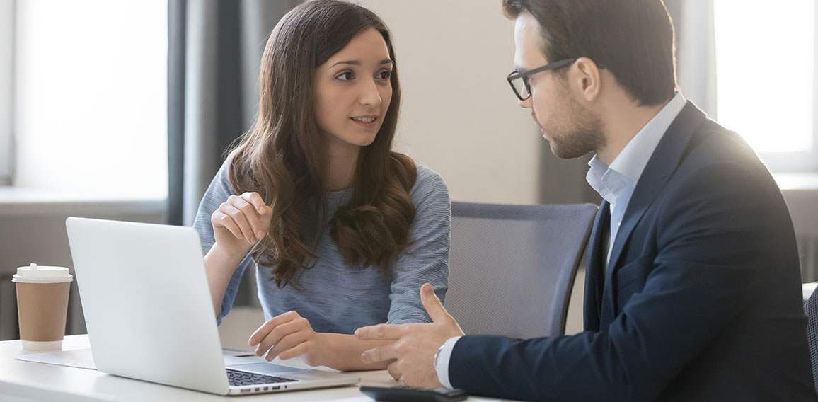 Female manager broker consulting client in corporate office with laptop