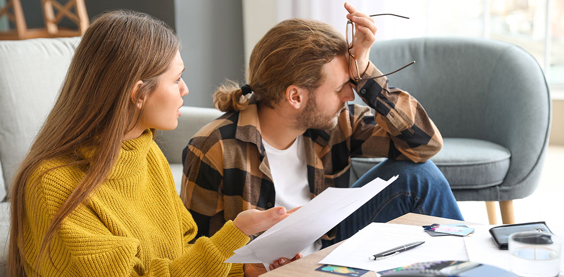 Worried young couple in debt at home