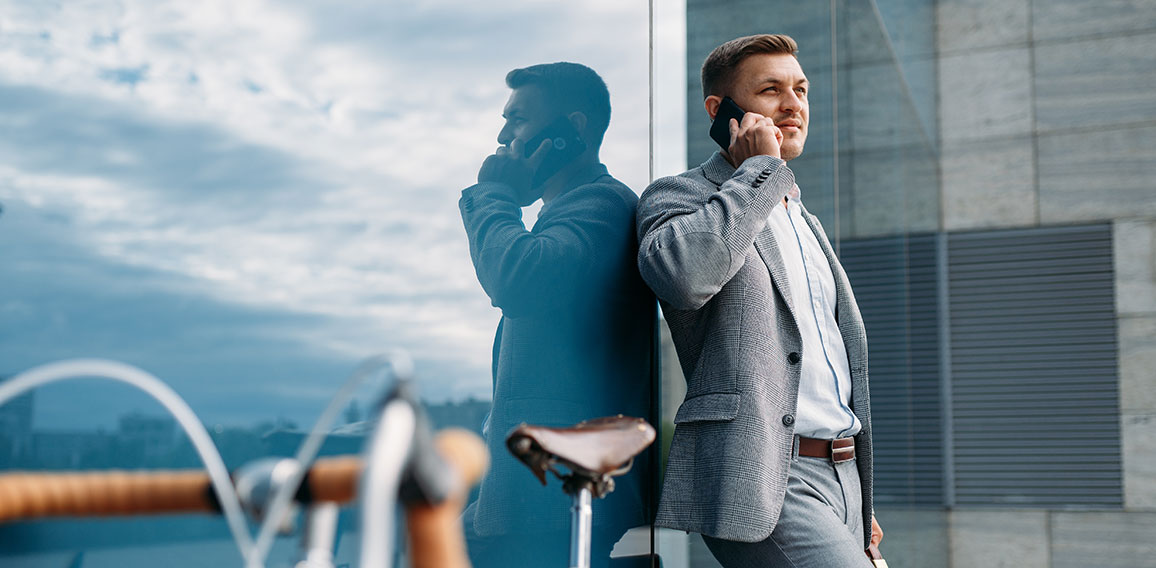 Businessman talking by mobile phone at the bicycle