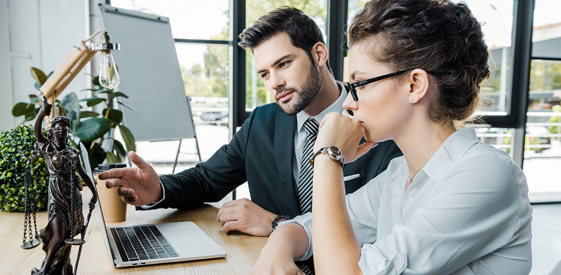 lawyers discussign work at workplace with laptop and femida in o