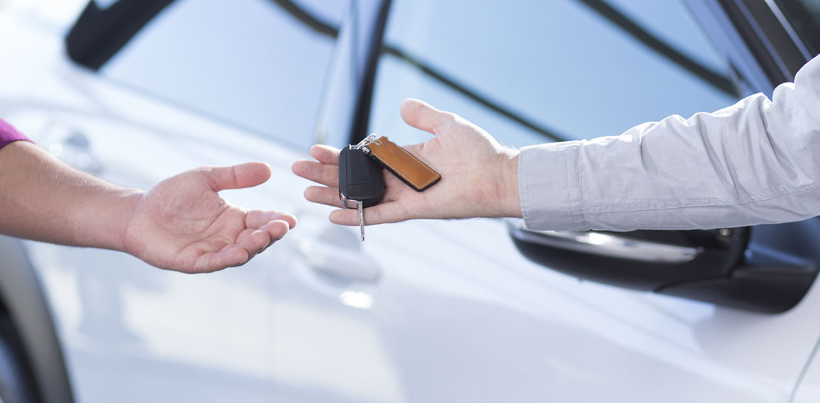 Panorama and close-up of car seller's hand with keys and buyer's