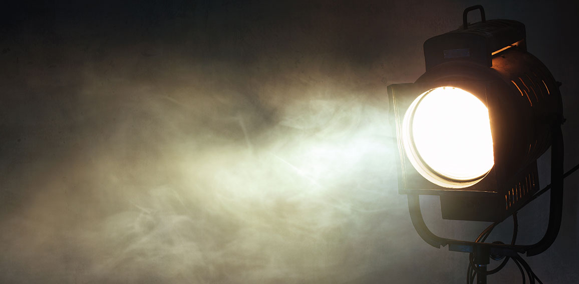 theater spot light with smoke against grunge wall