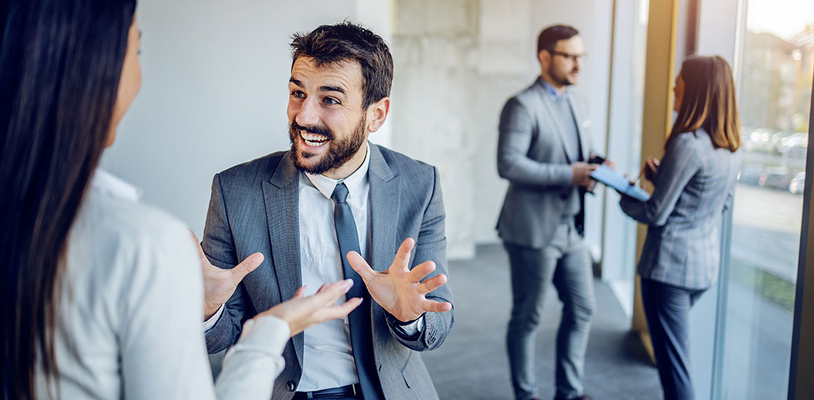 Cheerful caucasian businessman sitting on table in building in c