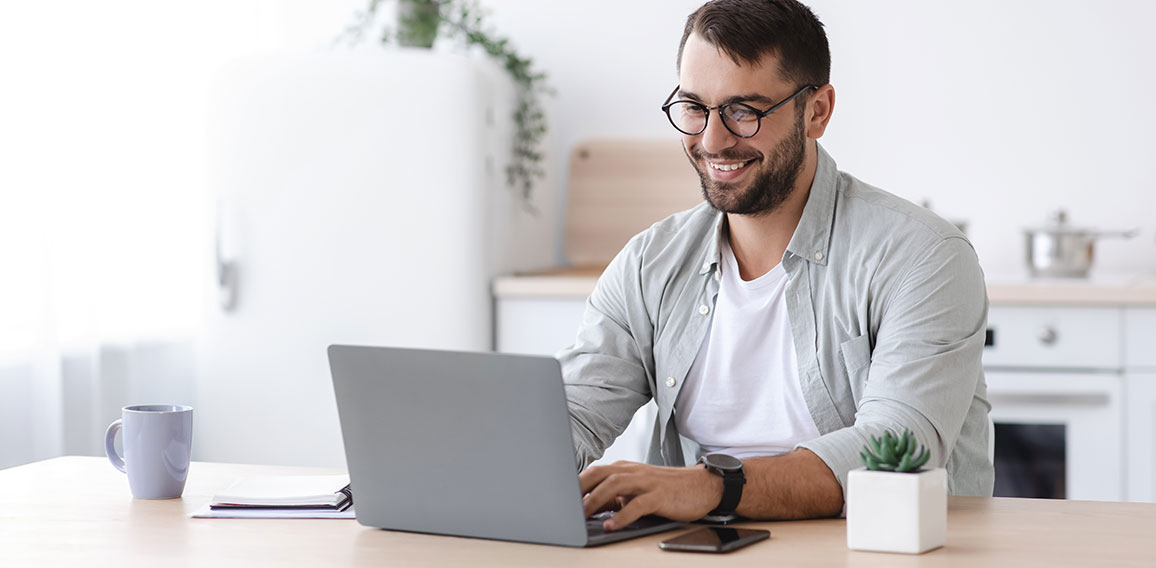 Happy handsome mature european male teacher or businessman with beard in glasses working at laptop