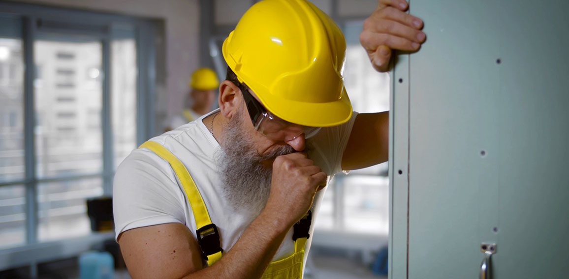 Senior construction worker sick and coughing in renovating apartment