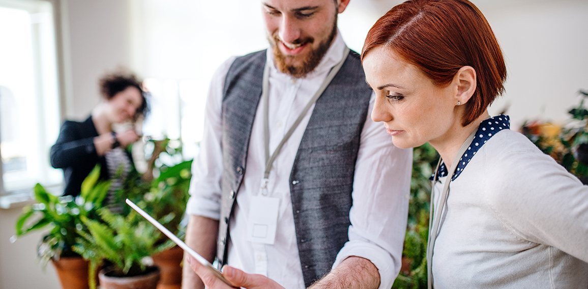 Two young businesspeople using tablet in office, start-up concept.