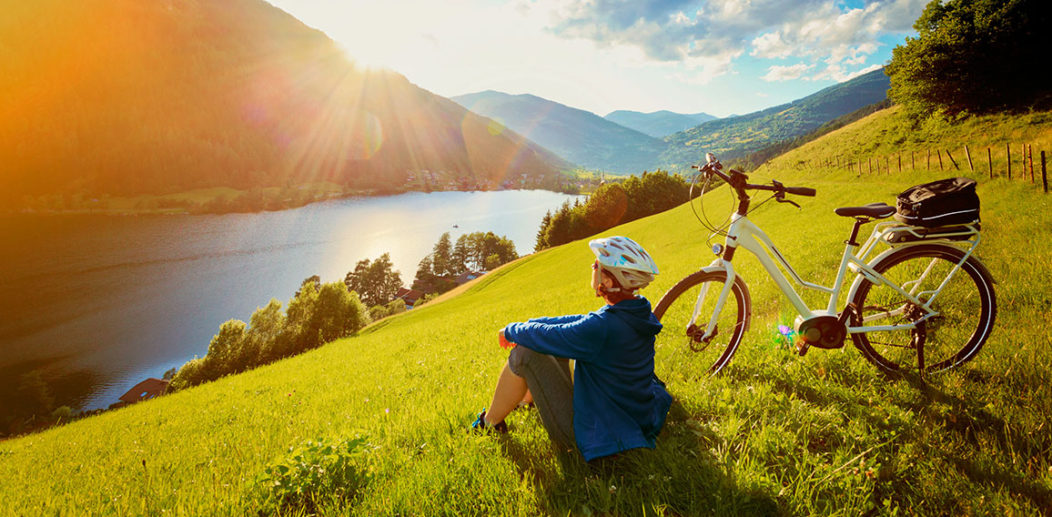 woman resting above a lake with her e-bike/e-power 14