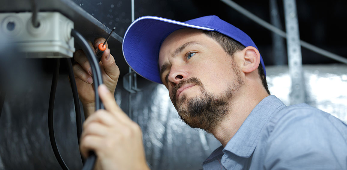 an electrician is fixing an electric cable