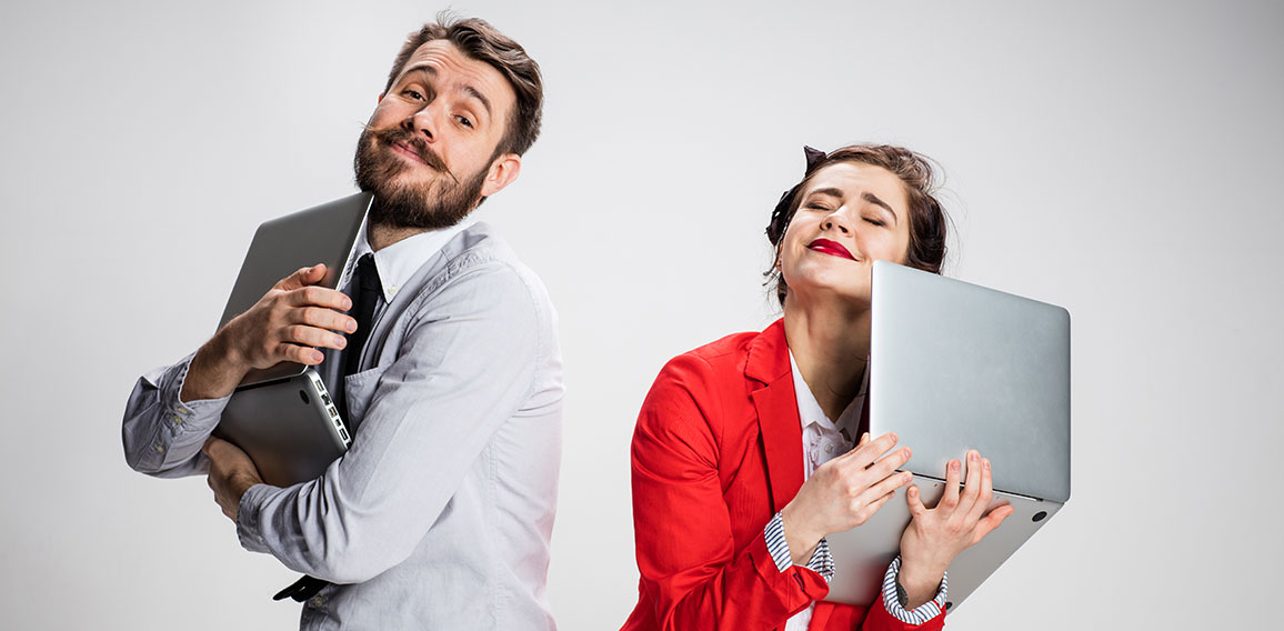 The young businessman and businesswoman with laptops on gray background