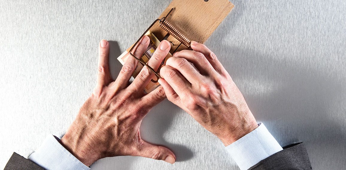 businessman removing his hand a mouse trap with bank note