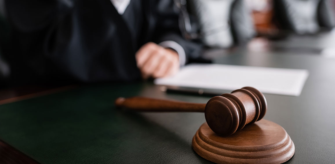 selective focus of wooden gavel near cropped judge on blurred background