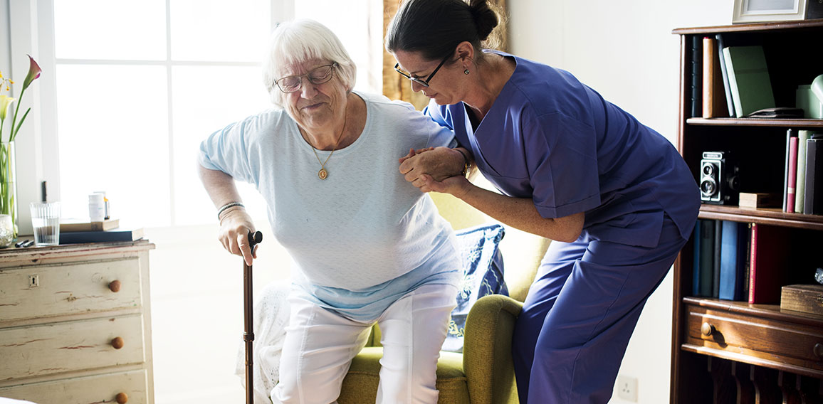 Nurse helping senior woman to stand