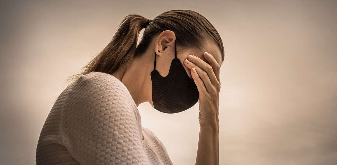 Stressed female wearing protective face mask. Coronavirus, fear,