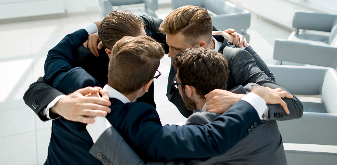 group of business people standing in a close circle.