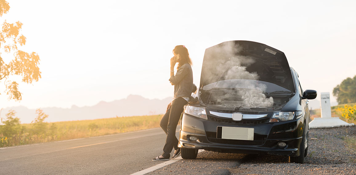 Broken car. Lady standing on the road