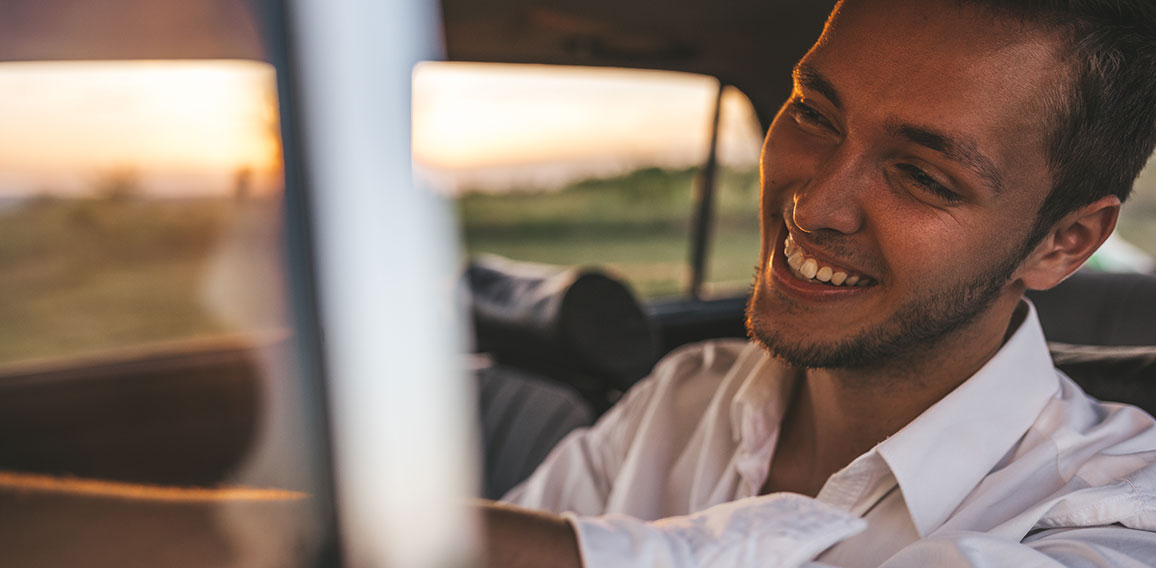 Closeup portrait of handsome happy male driver smiling while sit