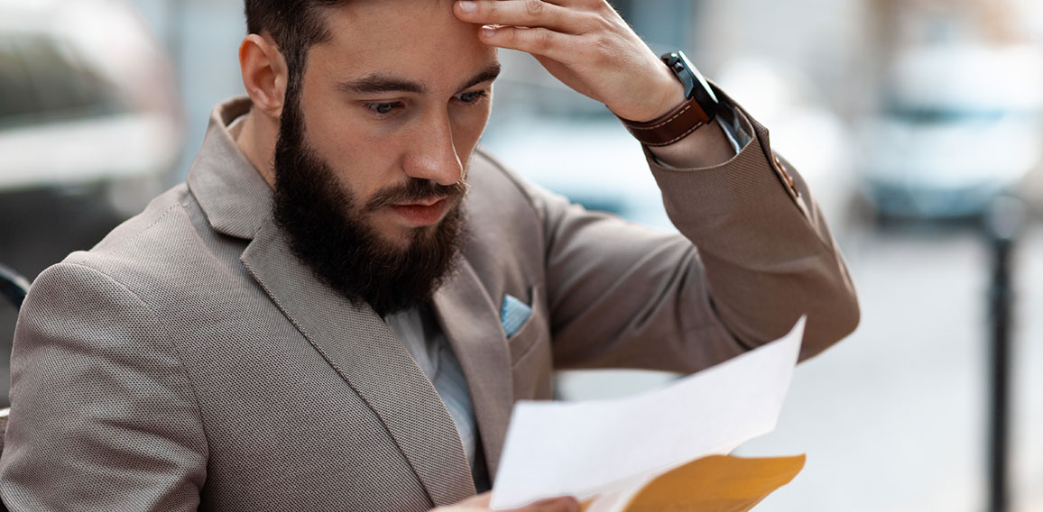 Big debt alert. A shocked man reads a court letter. Death of a l