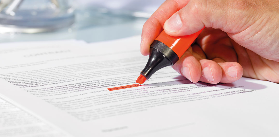 Close-up of hand with highlighter over document