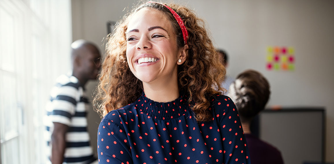 Laughing young designer standing in an office after a meeting