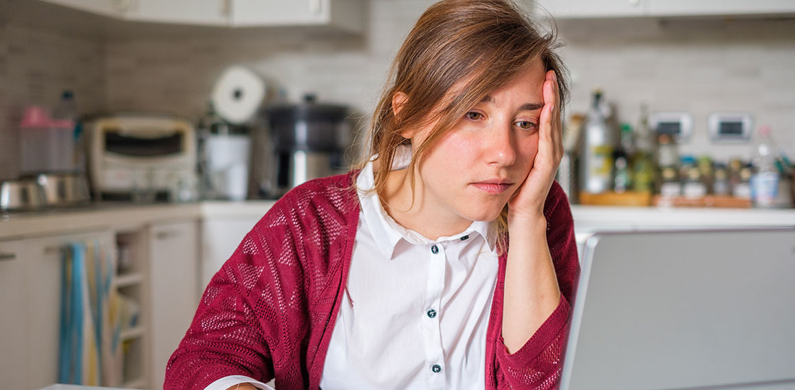 Stressed woman sitting at home and checking unpaid bills