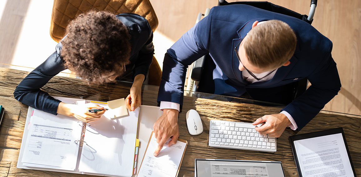 Businesspeople Using Laptop In Office