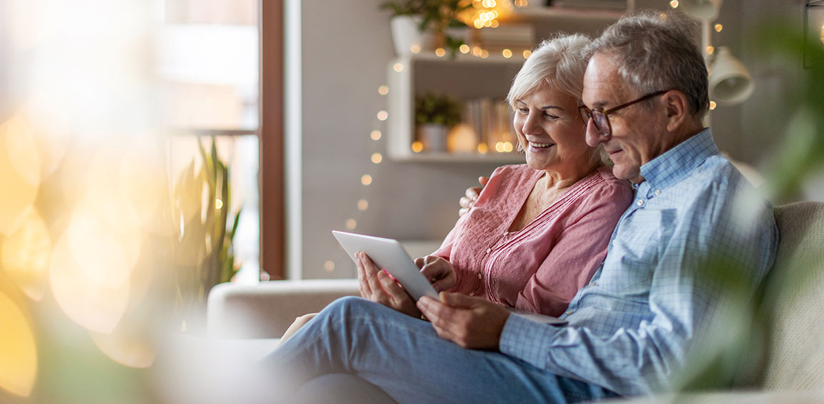 Mature couple using a laptop while relaxing at home