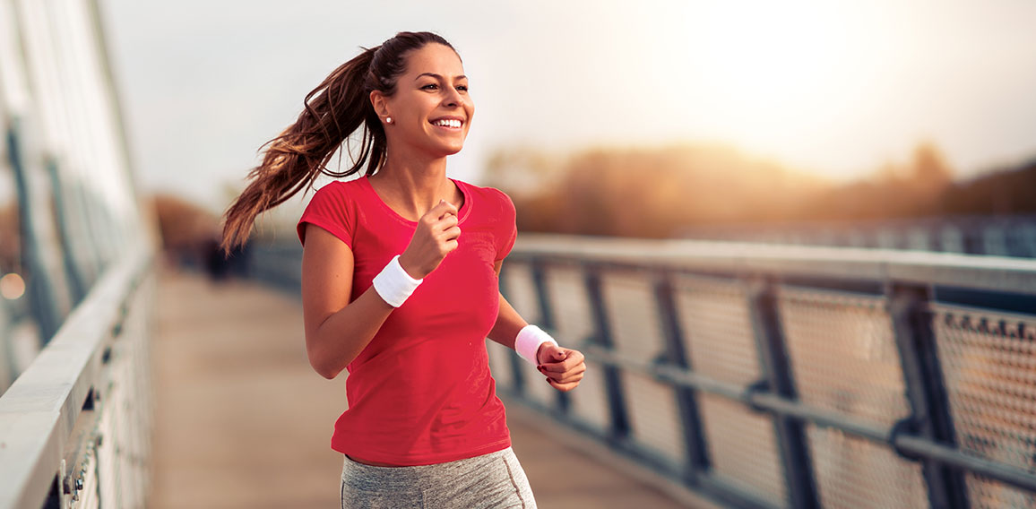 Beautiful woman running over bridge