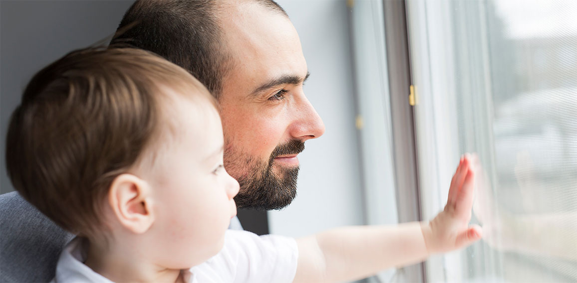 Father and son indoor near the window.