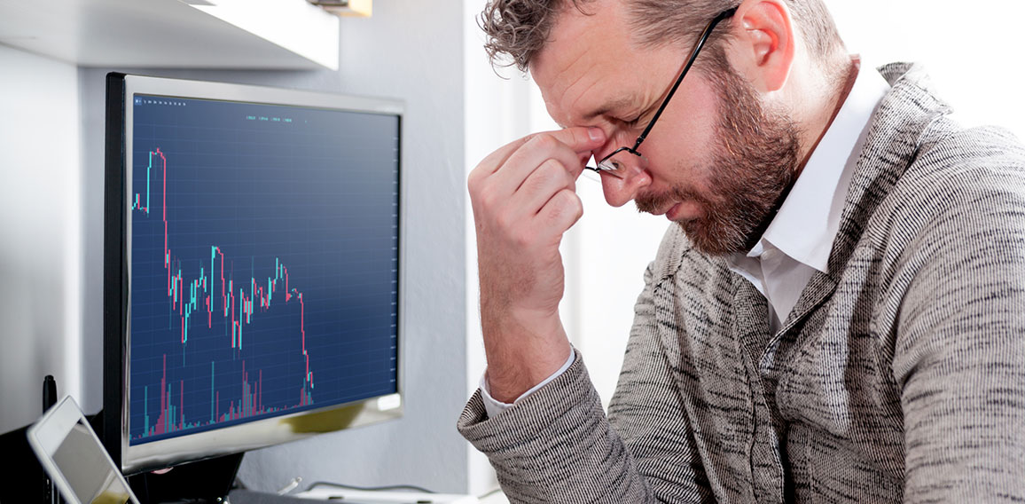 Depressed investor analyzing crisis stock market with graph on s