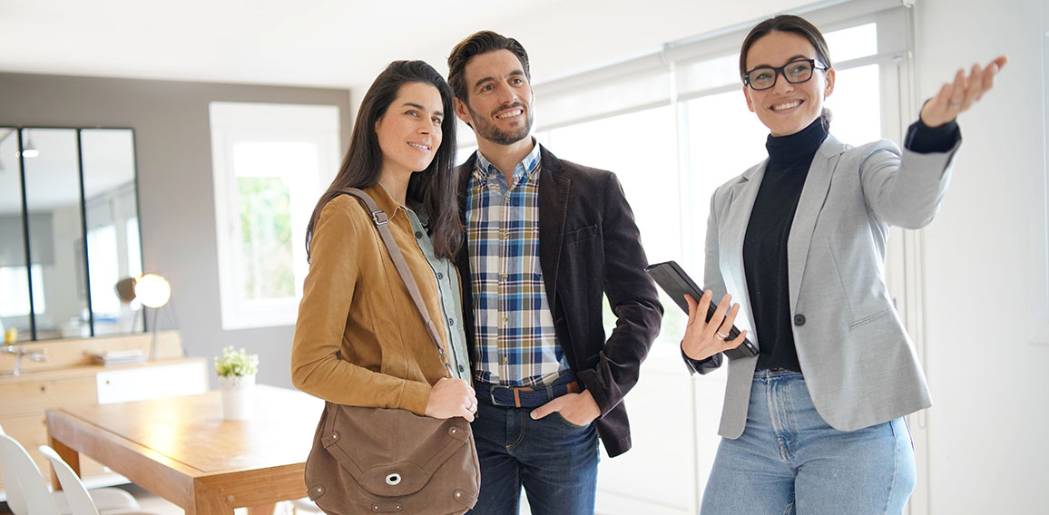 Real estate agent showing modern house to attractive couple