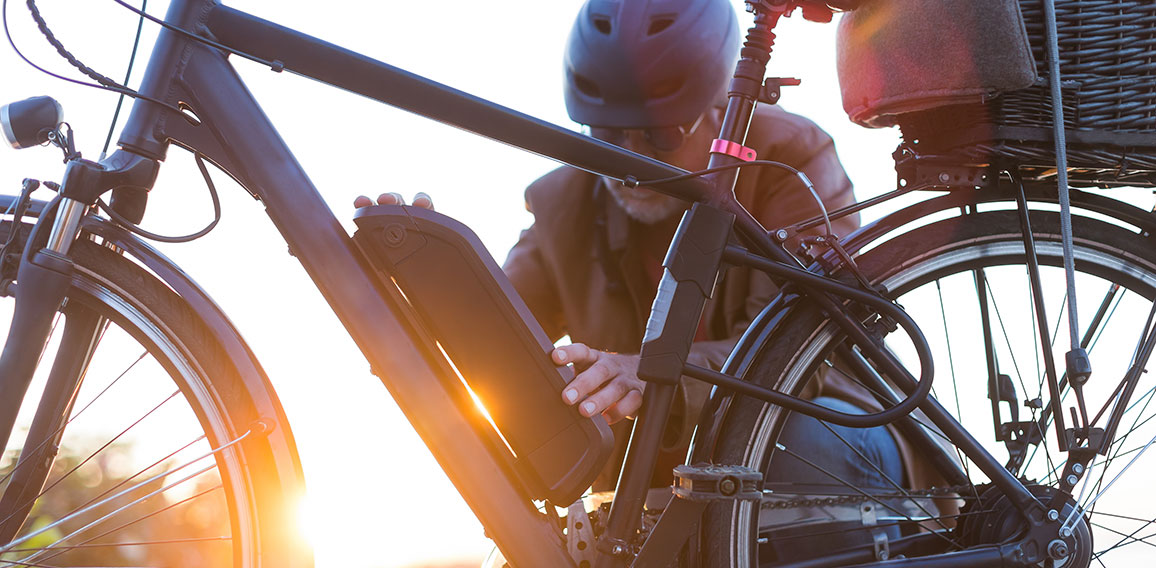 man changing electric bicycle battery