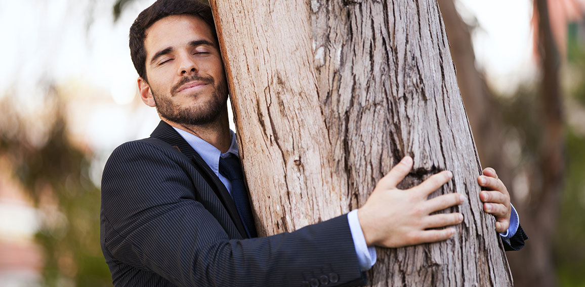 Businessman embrace a tree trunk