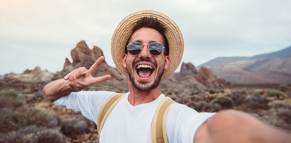 Handsome hiker taking a selfie hiking a mountain using his smart