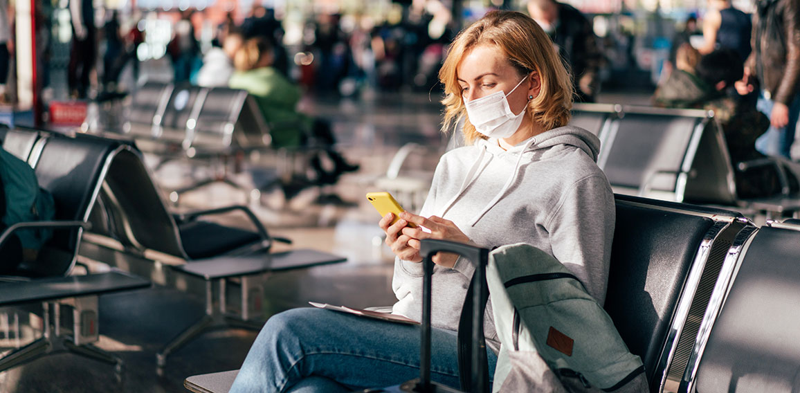 A European woman in a protective medical mask on her face sits a