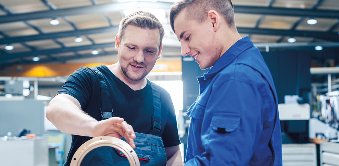 Master discussing a workpiece with his apprentice or trainee