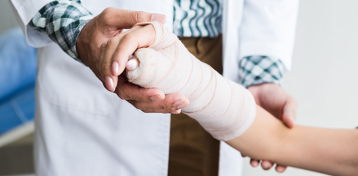 Close-up of man doctor of checking splint the arm of female pati