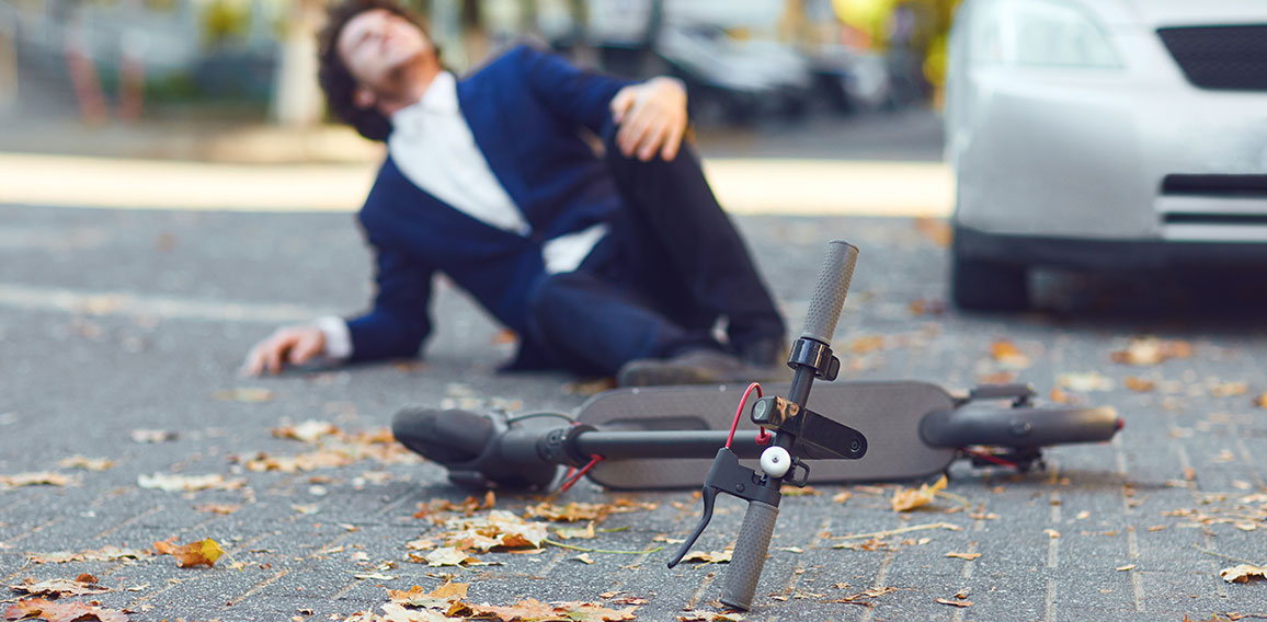 Accident with an electric scooter. A man fell from a scooter on a city street.