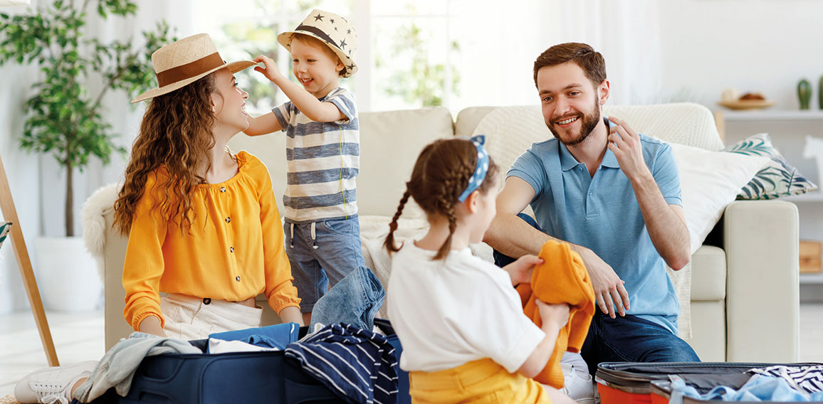 Playful family packing for holiday at home