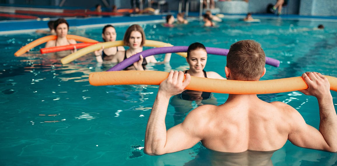 Instructor and group on workout in swimming pool