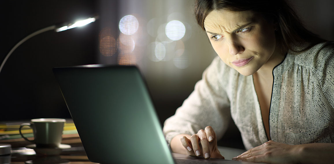 Suspicious woman checking laptop content in the night