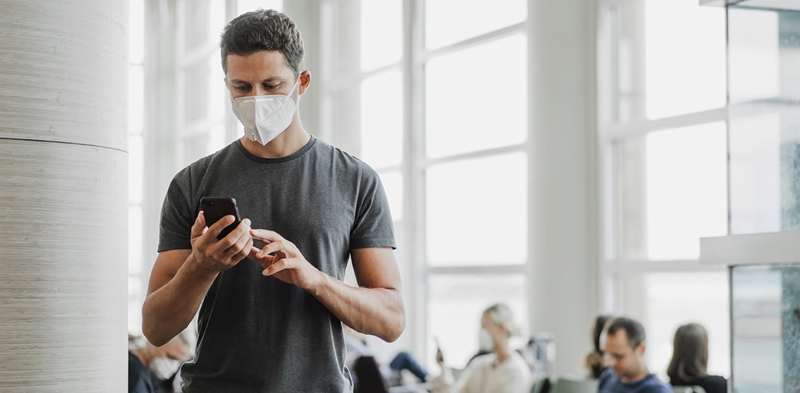 Men with respirator mask in airport. Covid-19 and Air pollution concept.