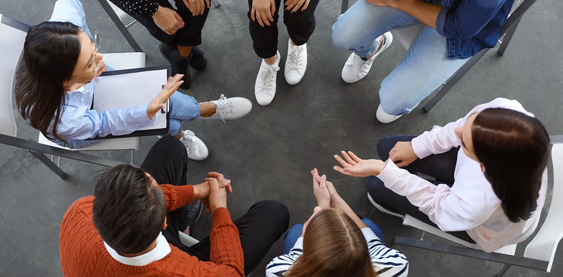 Psychotherapist working with patients in group therapy session,