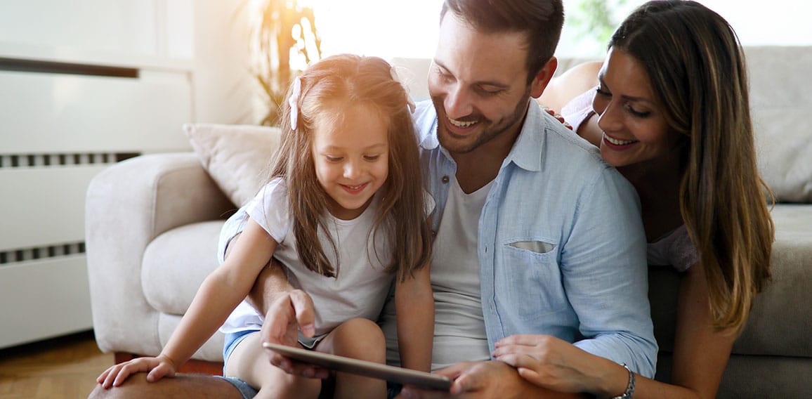 Family holding a tablet and looking at it