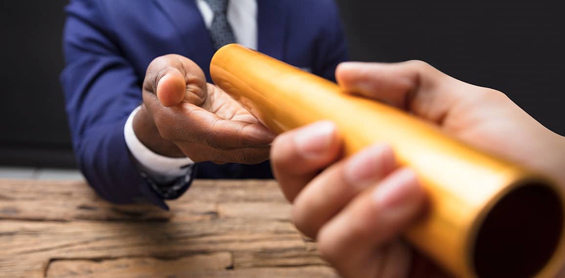 Businessman Passing Baton To His Partner