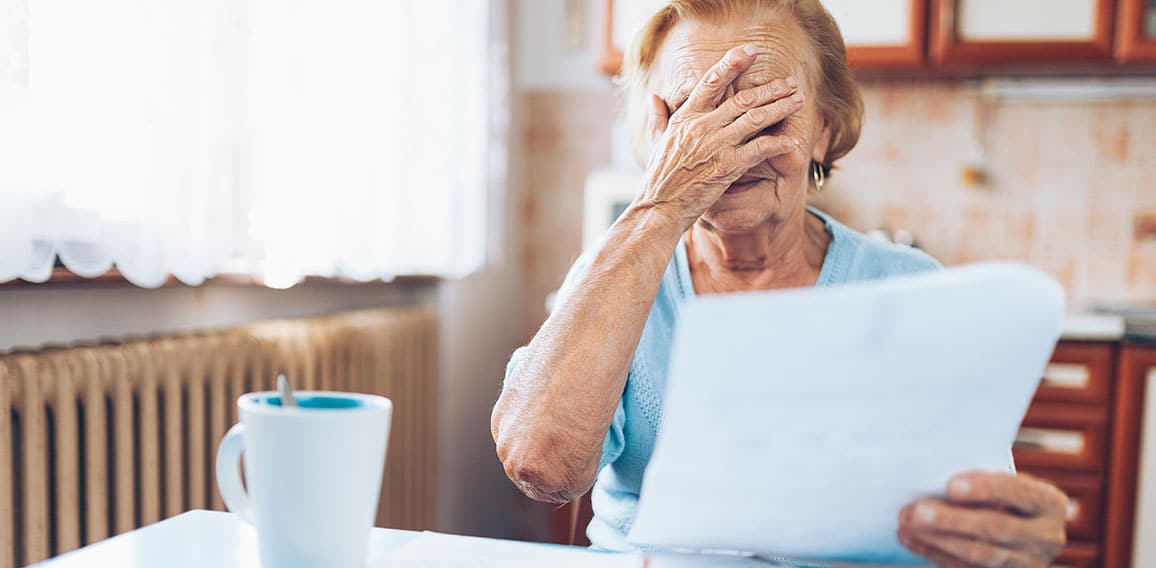 Elderly woman looking at her utility bills