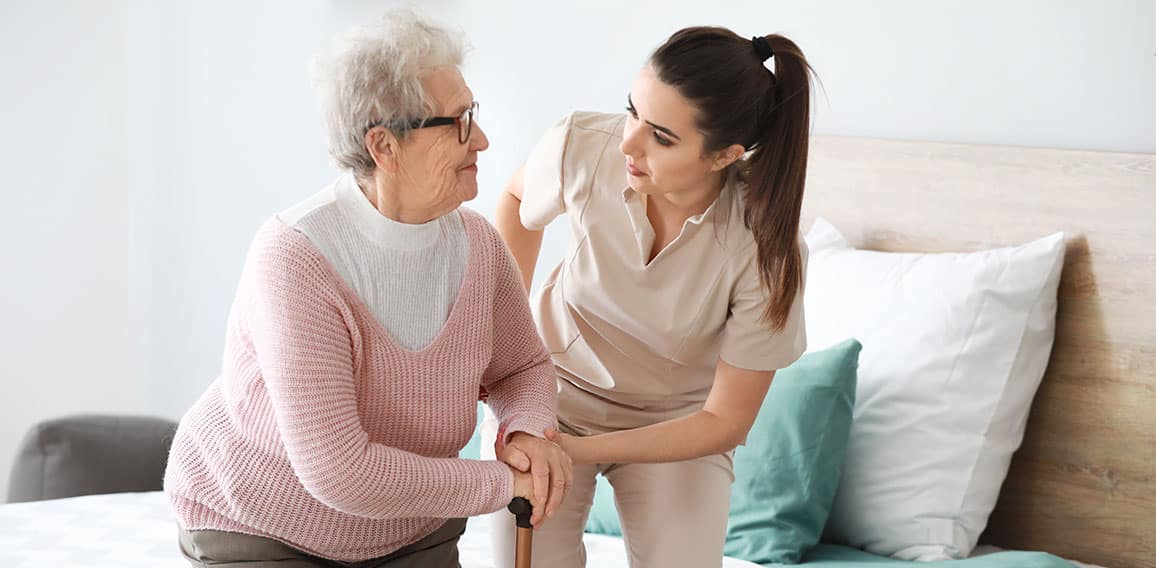 Caregiver with senior woman in nursing home