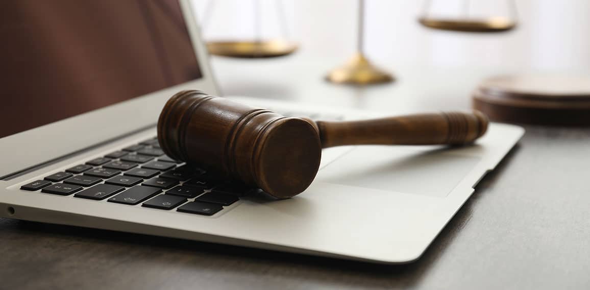 Laptop, gavel and scales on table, closeup. Cyber crime