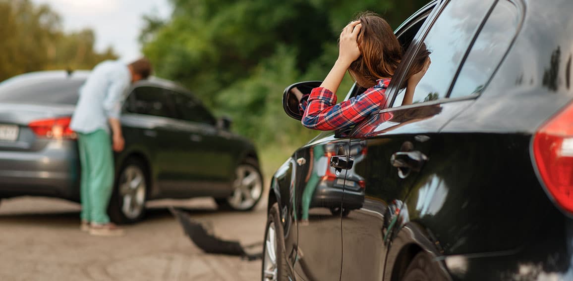 Male and female drivers after car accident on road