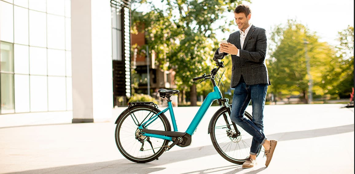 Young businessman on the ebike using mobile phone